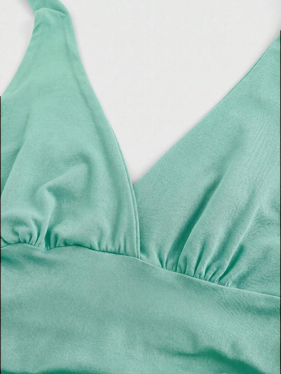 Women's halter crop tank top featuring a backless silhouette and ruched detailing in a slim fit design.