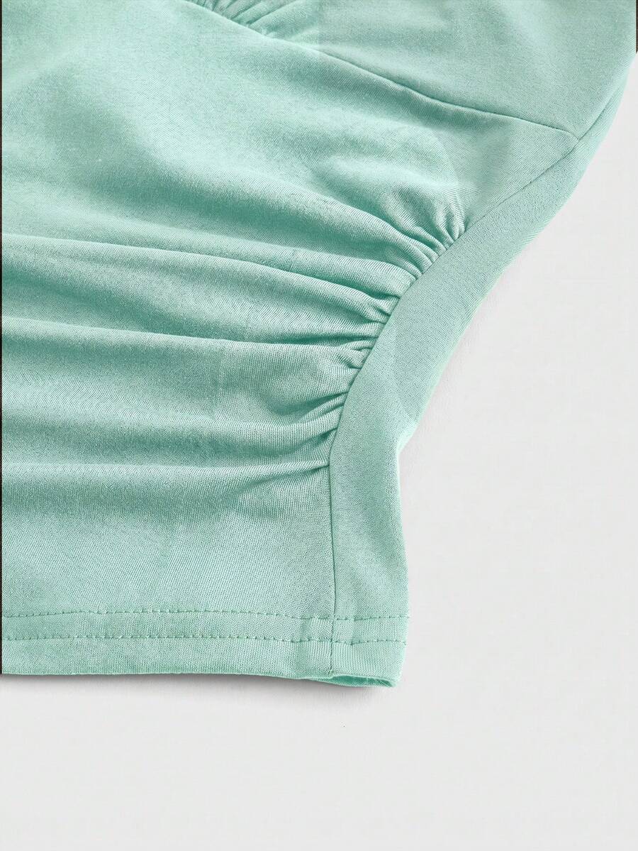Women's halter crop tank top featuring a backless silhouette and ruched detailing in a slim fit design.