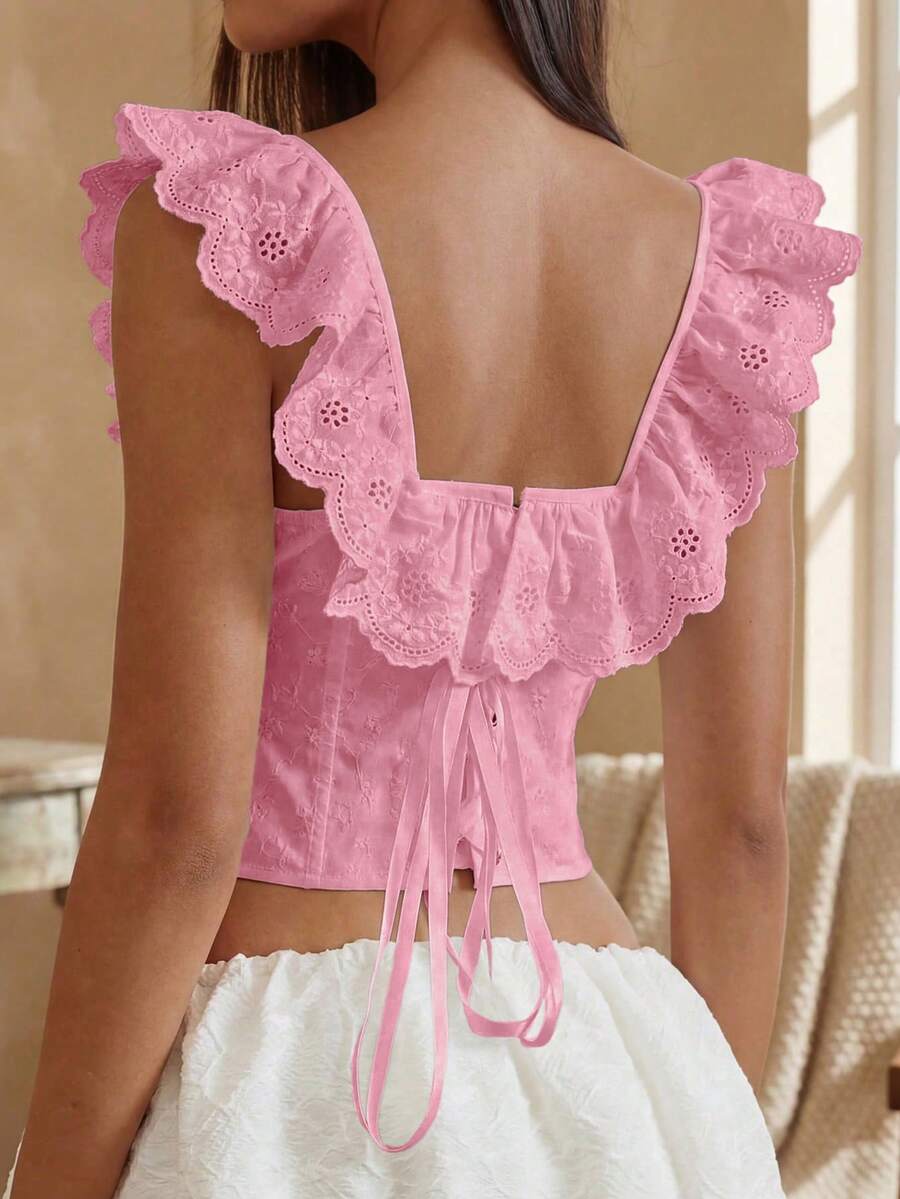Women’s white corset top with embroidered ruffle trim, off-shoulder neckline, lace-up details, front hook closure, and sleeveless crop fit.