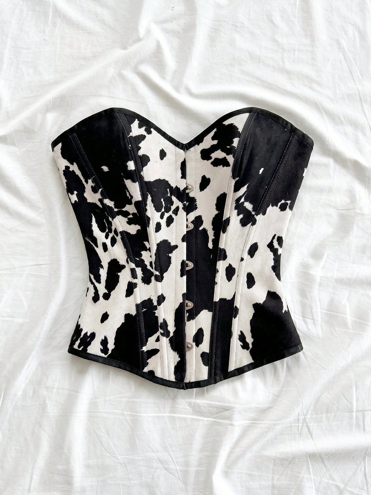 Strapless black lace-up corset top for women with grommet eyelet details, slim fit, lined body, and woven fabric construction.