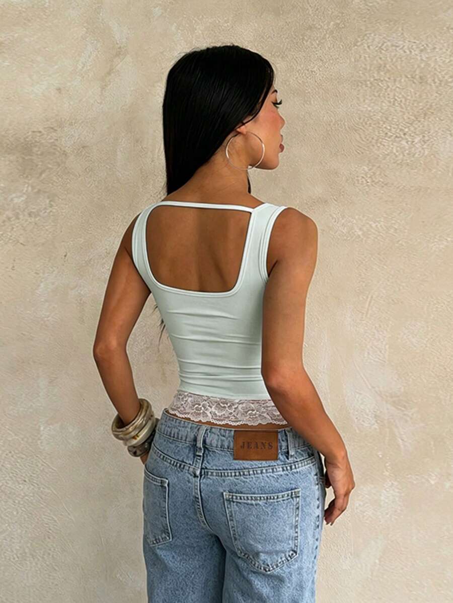 Women's white sleeveless crop top with contrast lace trim, shoulder straps, and a floral graphic print.