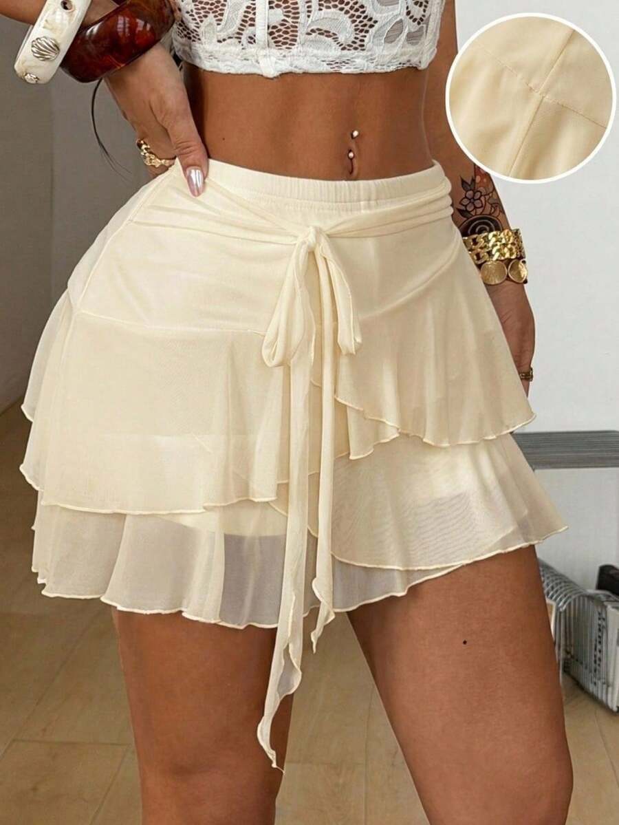 Black low waist tiered mini skirt featuring a ruffle hem and ring accent detail on knitted stretch fabric for women.