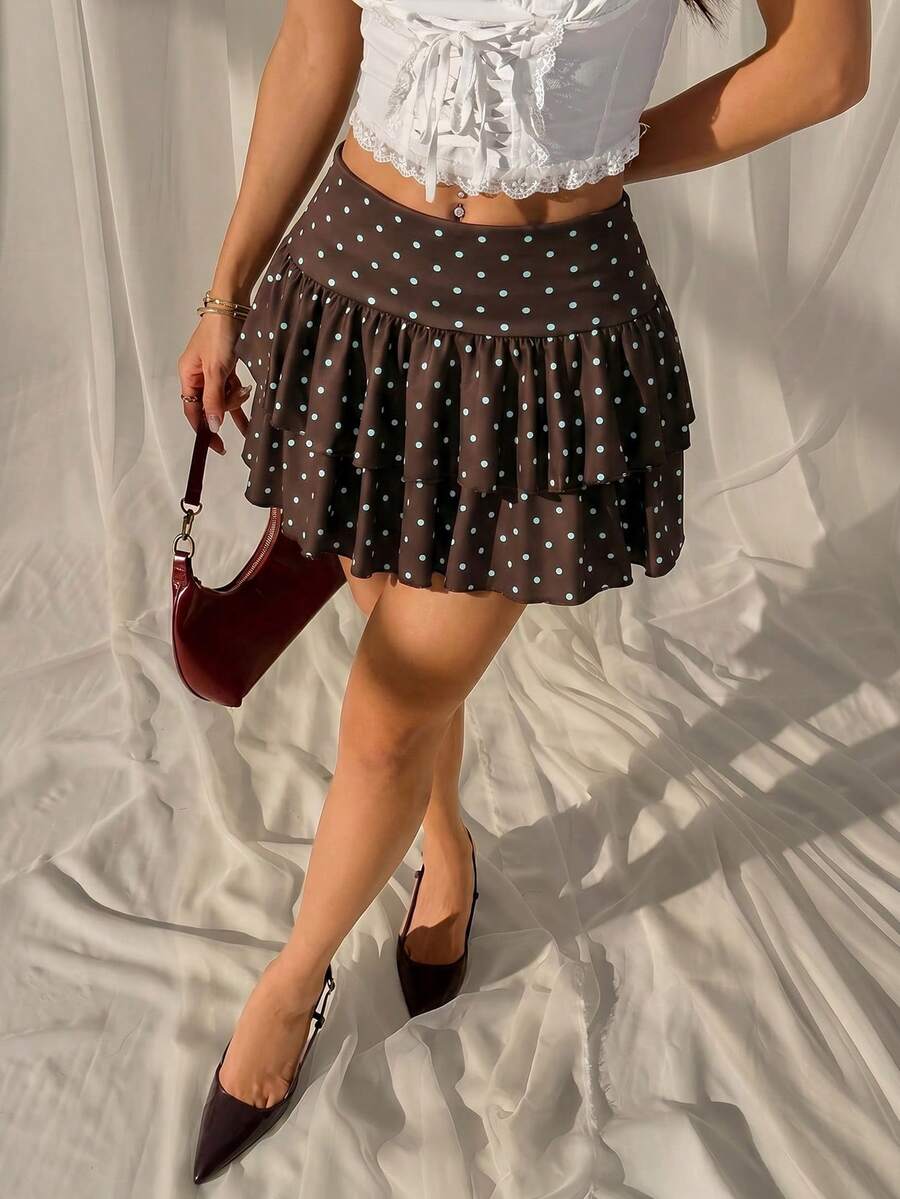 Black low waist knit mini skirt featuring a tiered ruffle hem and skinny high stretch fit.