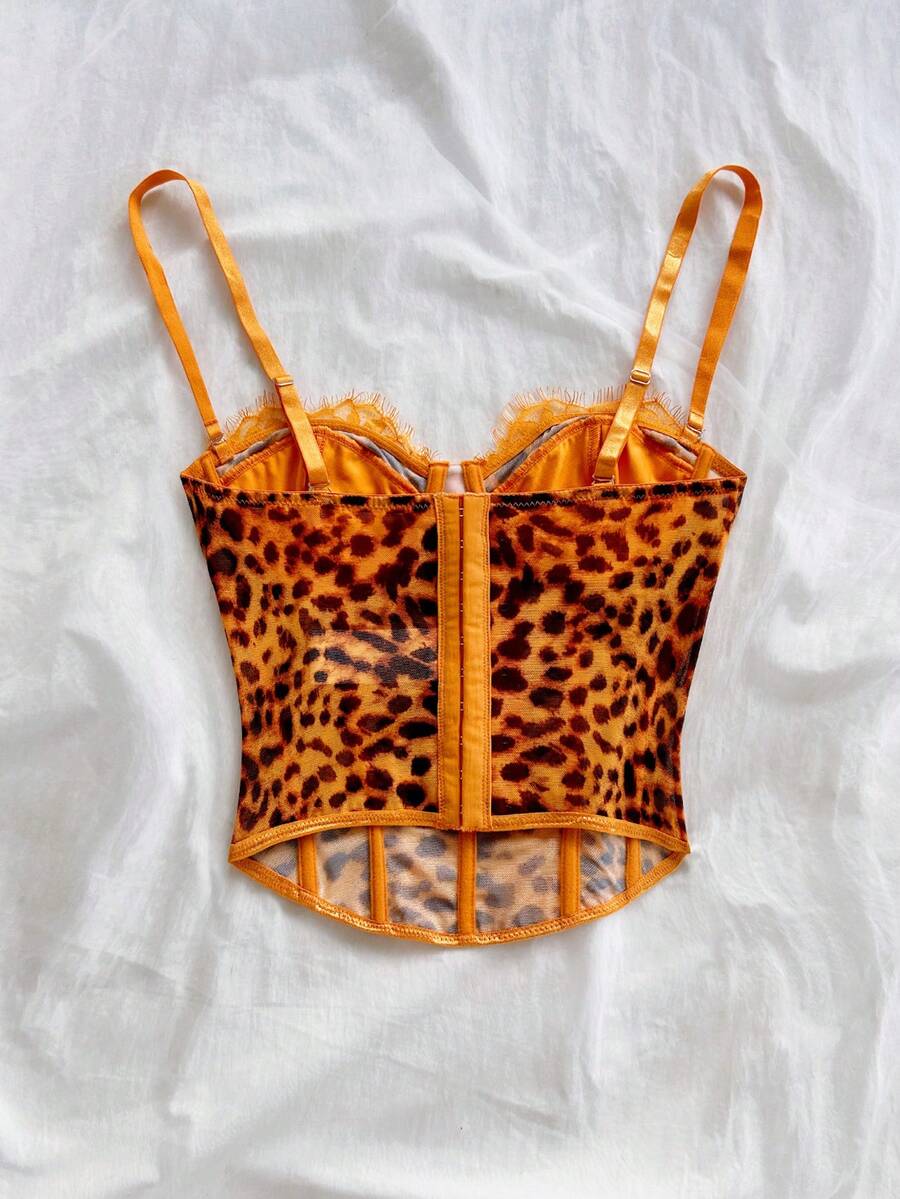 Women's lace bustier camisole top with spaghetti straps, contrast lace, lace-up detail, and an asymmetrical hem in a slim fit design.