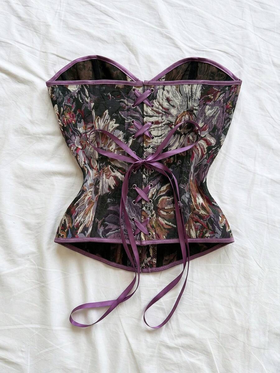 Strapless black lace-up corset top for women with grommet eyelet details, slim fit, lined body, and woven fabric construction.