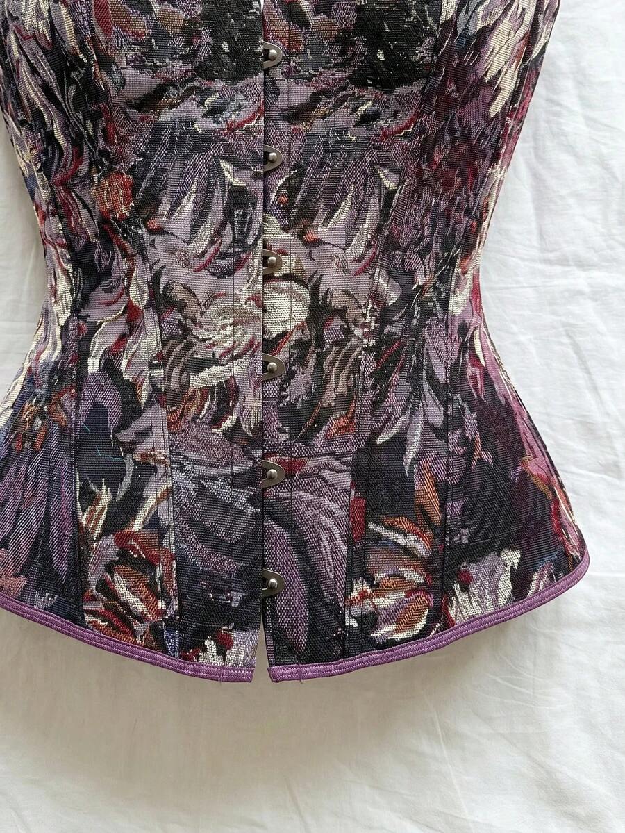 Strapless black lace-up corset top for women with grommet eyelet details, slim fit, lined body, and woven fabric construction.