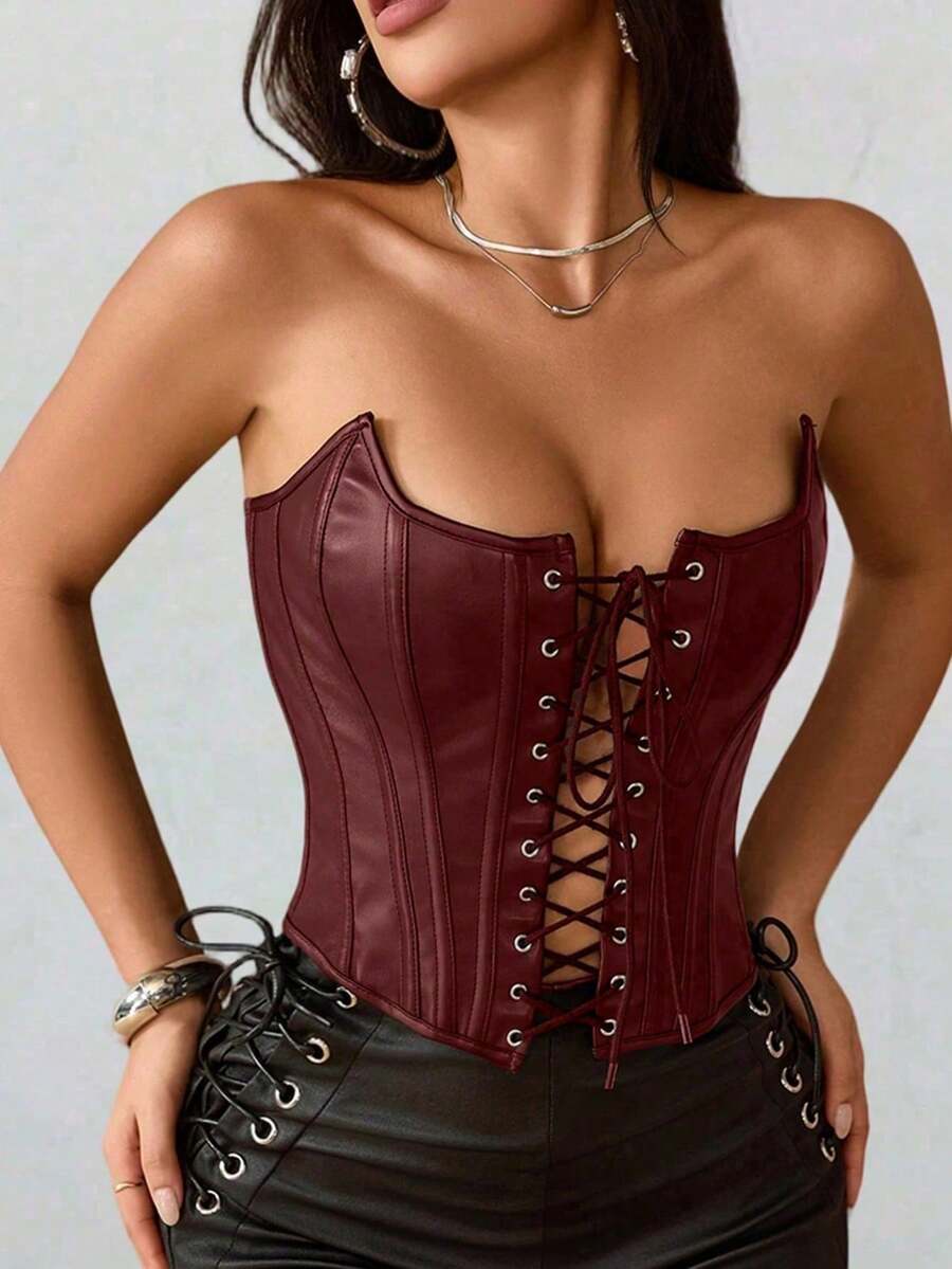 Black PU leather strapless bustier corset crop top featuring boned structure, lace-up grommet eyelets, and an asymmetrical hem on a women model.