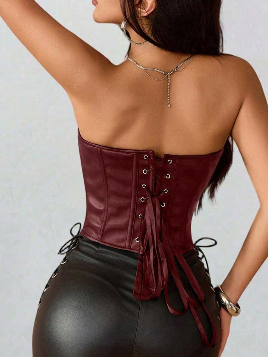Black PU leather strapless bustier corset crop top featuring boned structure, lace-up grommet eyelets, and an asymmetrical hem on a women model.