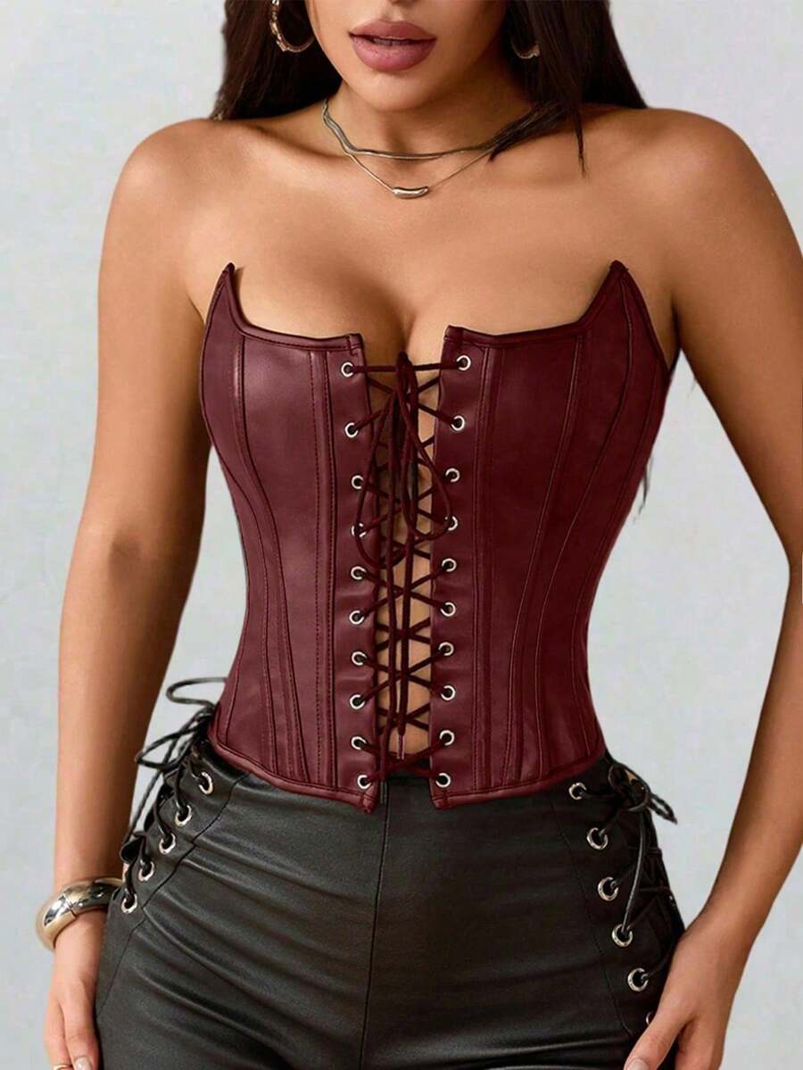 Black PU leather strapless bustier corset crop top featuring boned structure, lace-up grommet eyelets, and an asymmetrical hem on a women model.
