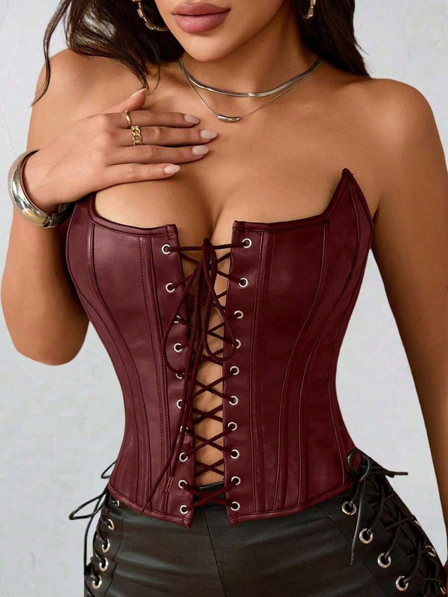 Black PU leather strapless bustier corset crop top featuring boned structure, lace-up grommet eyelets, and an asymmetrical hem on a women model.