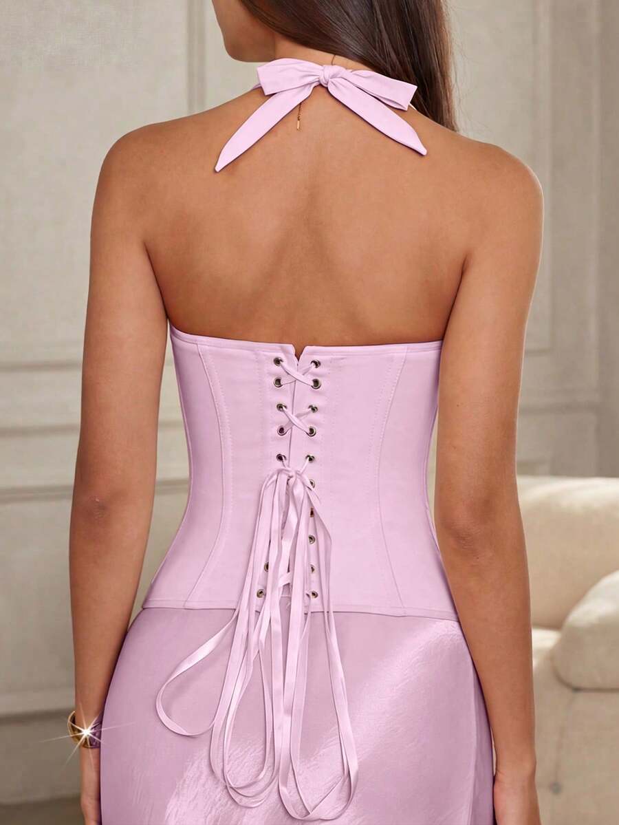 Women's white Y2K style corset cami top featuring a halter neckline, ruched detailing, asymmetrical hem, and backless lace-up design.