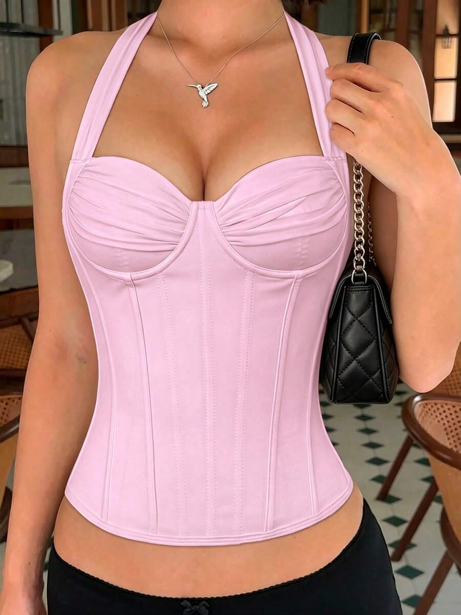 Women's white Y2K style corset cami top featuring a halter neckline, ruched detailing, asymmetrical hem, and backless lace-up design.