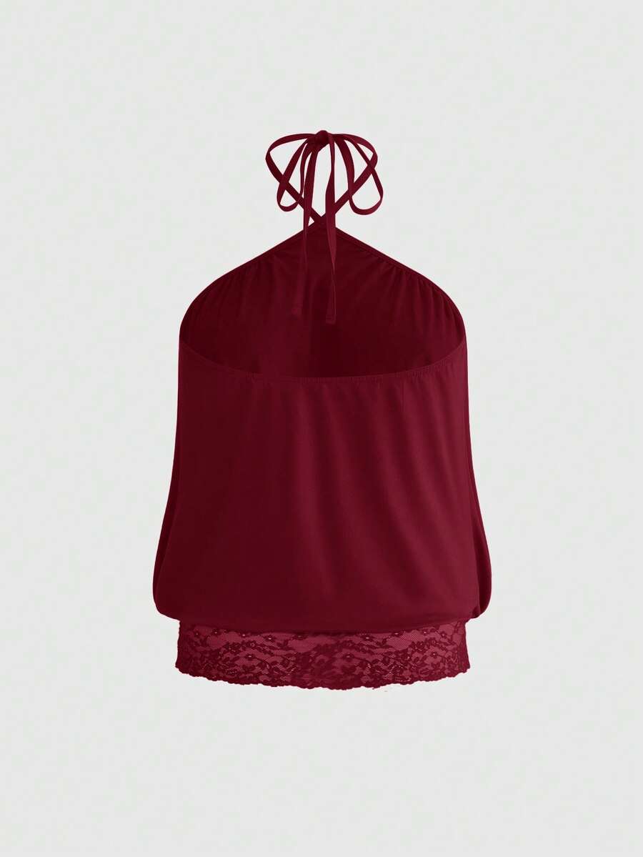 Woman wearing a black slim fit halter camisole crop top with lace-up backless tie detail.