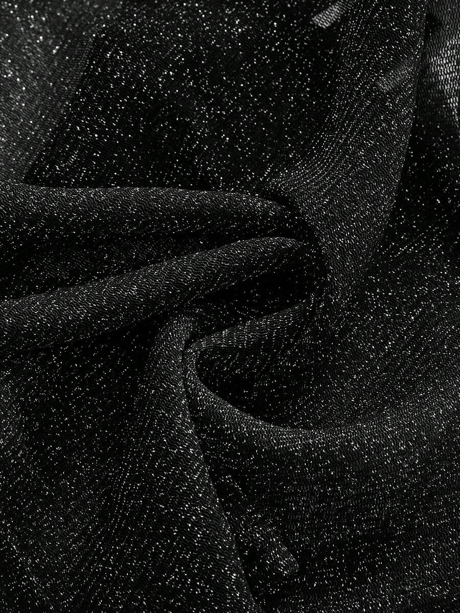 Women's glitter backless halter crop top with a draped neck and tie-up straps in metallic black knit fabric.