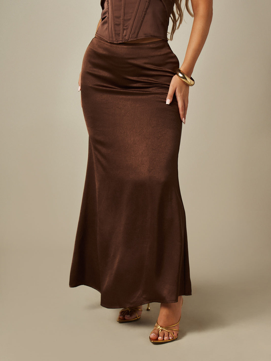 Brown satin maxi skirt featuring ruched detailing and a low waist mermaid fit for women.