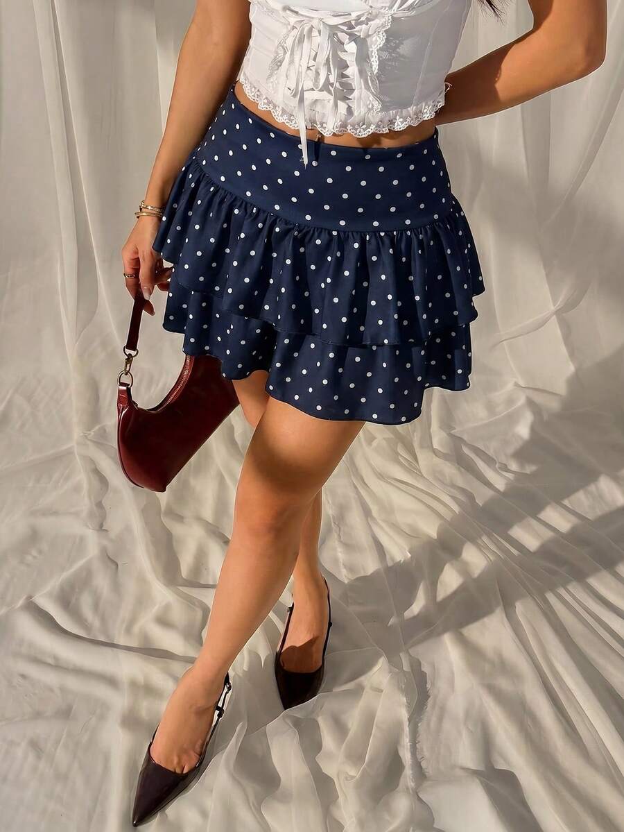 Black low waist knit mini skirt featuring a tiered ruffle hem and skinny high stretch fit.