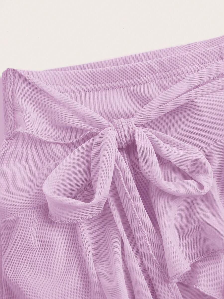 White tiered ruffle trim mini skirt for women with low waist, knot detail, mesh fabric, and casual Y2K boho design.