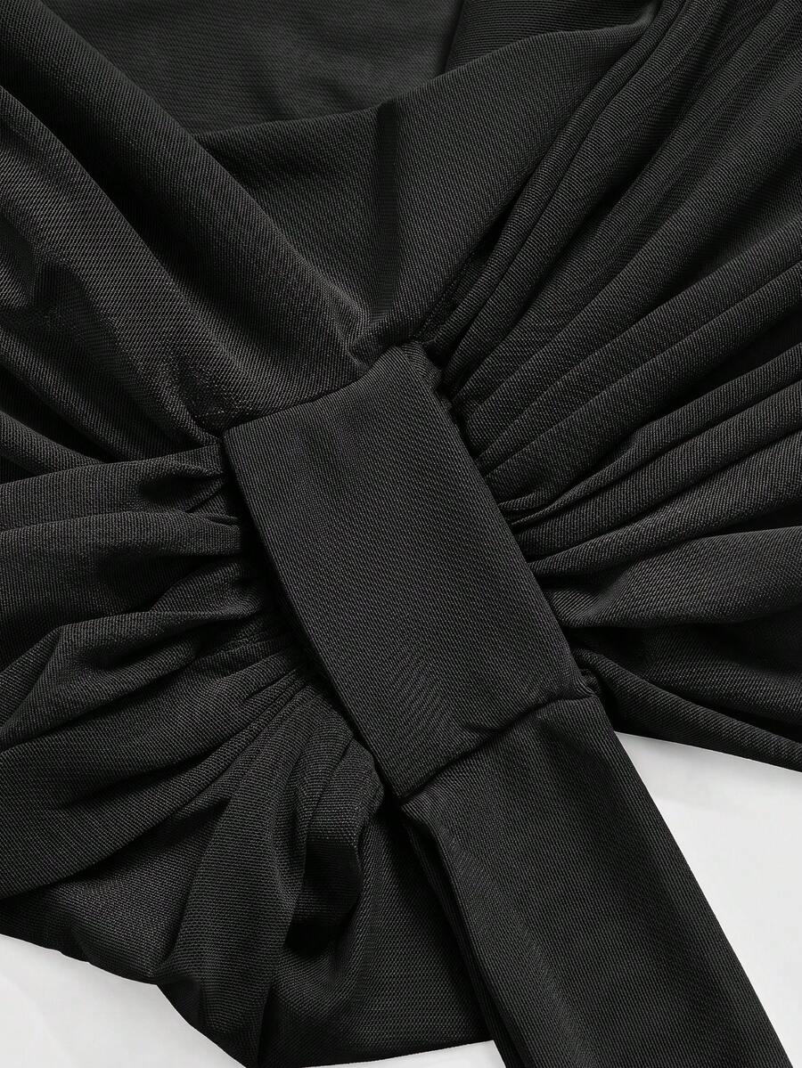 Black sheer mesh halter cami top featuring a backless design, asymmetrical hem, and knot details.