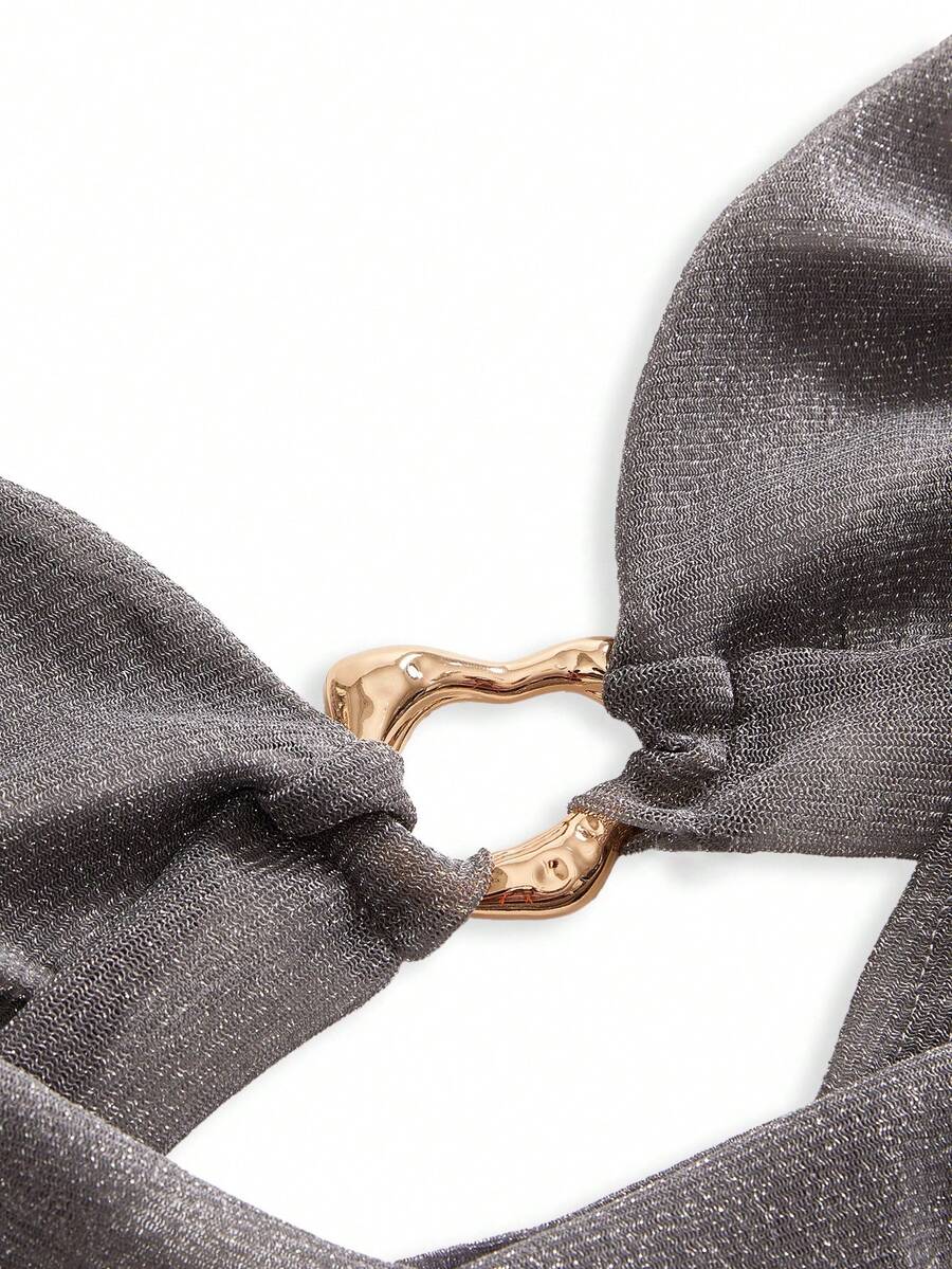Women's glitter backless halter crop top with a draped neck and tie-up straps in metallic black knit fabric.