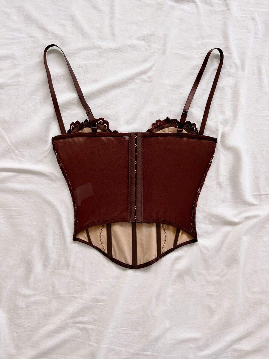 Women's lace bustier camisole top with spaghetti straps, contrast lace, lace-up detail, and an asymmetrical hem in a slim fit design.