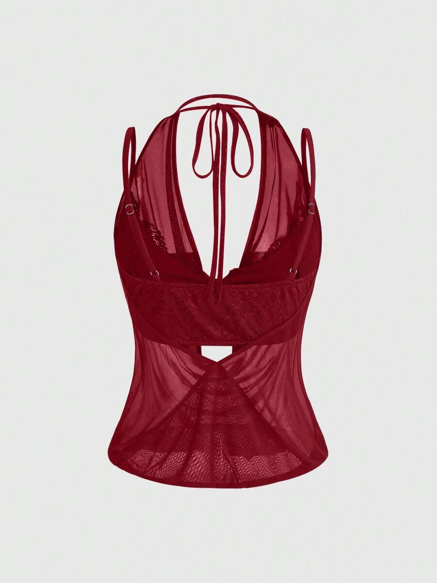 Women wearing a black draped backless halter crop top layered over a boned lace camisole.