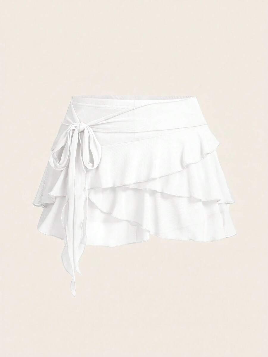 White tiered ruffle trim mini skirt for women with low waist, knot detail, mesh fabric, and casual Y2K boho design.