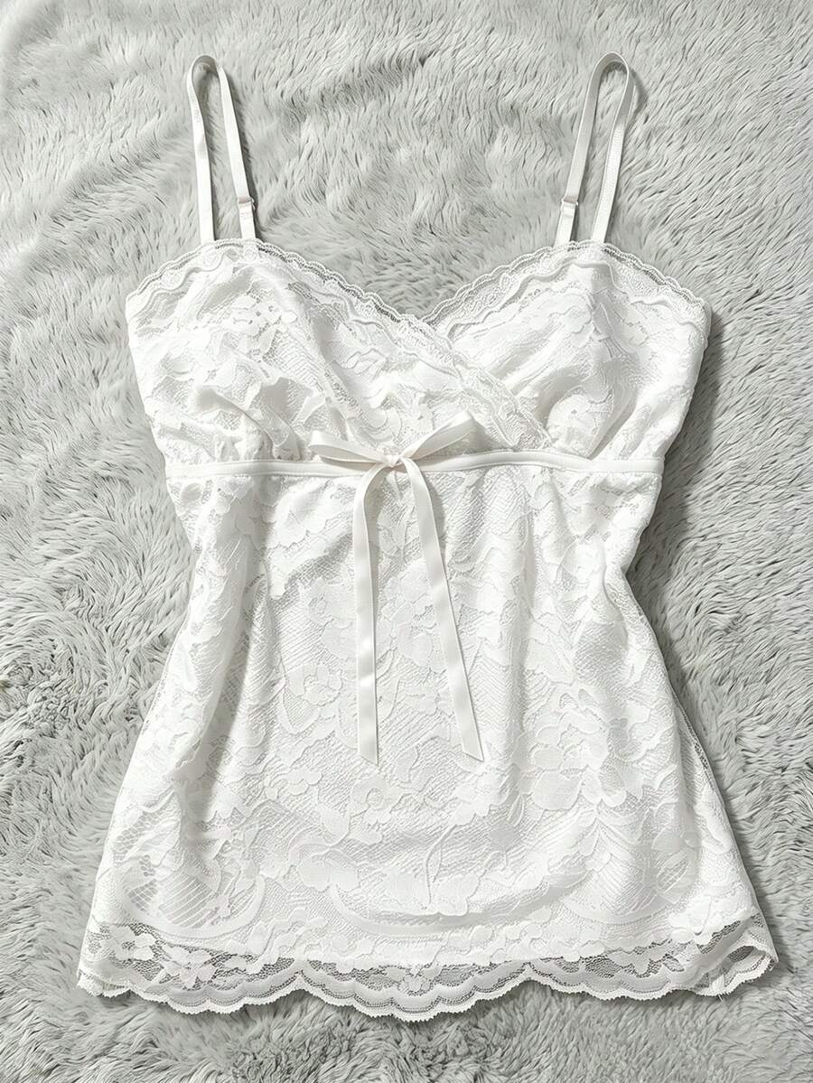 Women's solid color elegant lace cami top featuring contrast lace trim, cinched waist, spaghetti straps, and backless ring detail.