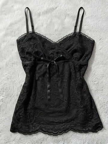 Women's solid color elegant lace cami top featuring contrast lace trim, cinched waist, spaghetti straps, and backless ring detail.