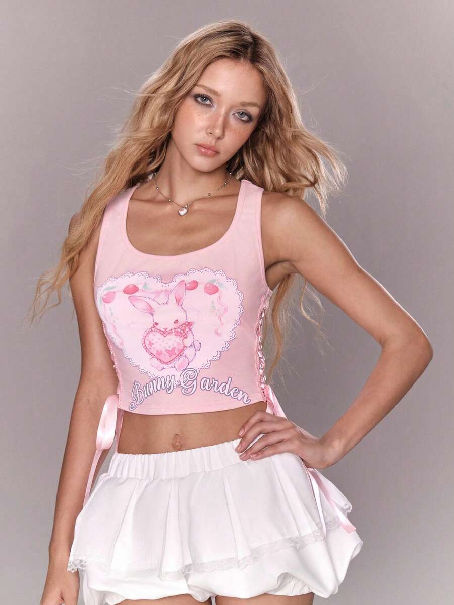 Pink slim fit cropped tank top with scoop neckline, featuring cute rabbit and heart print, rhinestone details, and front ribbon bow accent.