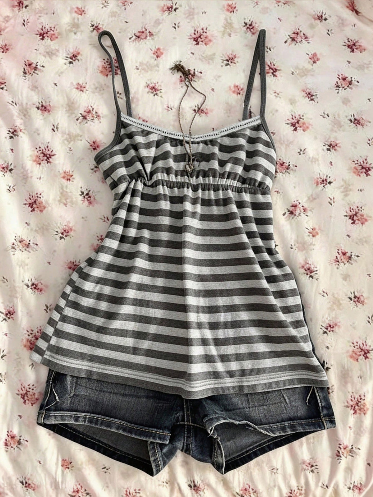 A women's black striped camisole top featuring spaghetti straps, a backless design with ring detail, and high-stretch knitted fabric.
