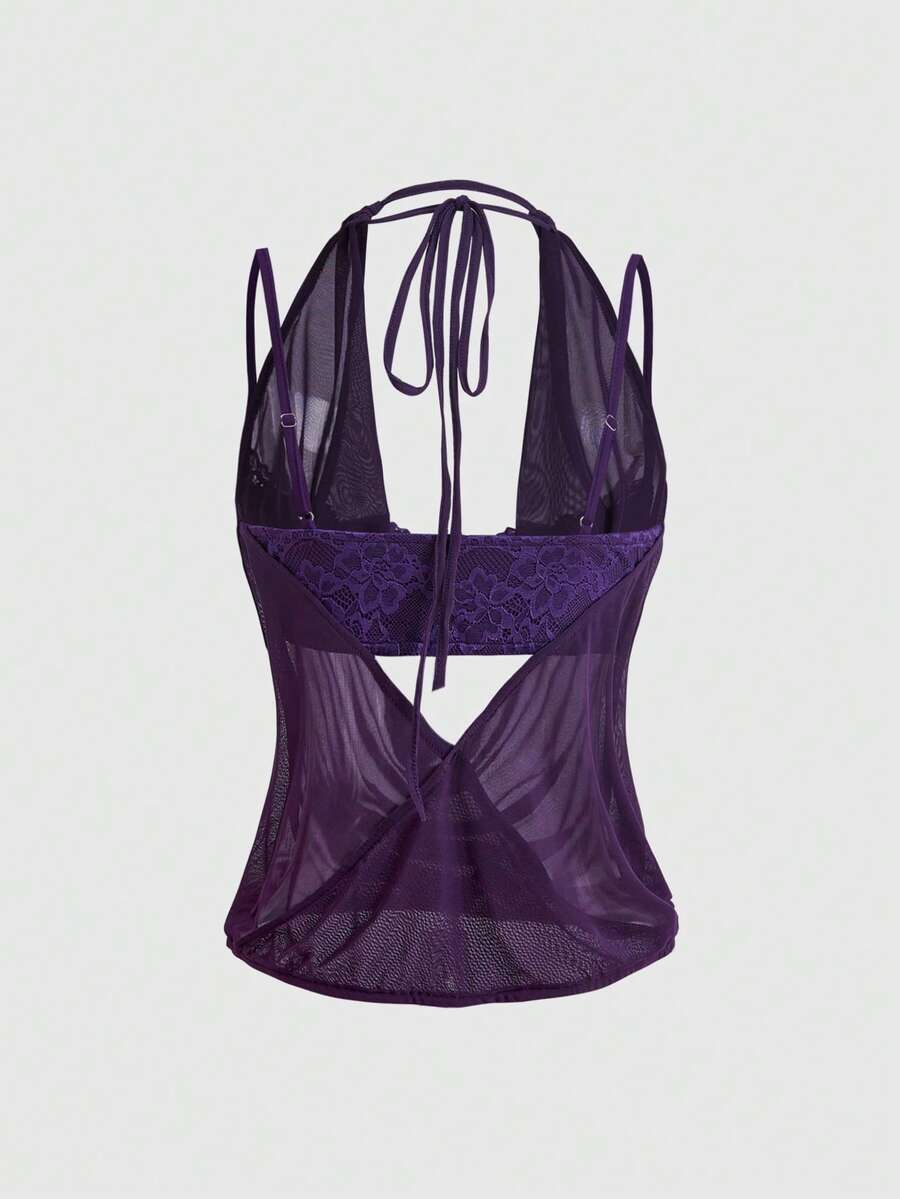 Women wearing a black draped backless halter crop top layered over a boned lace camisole.
