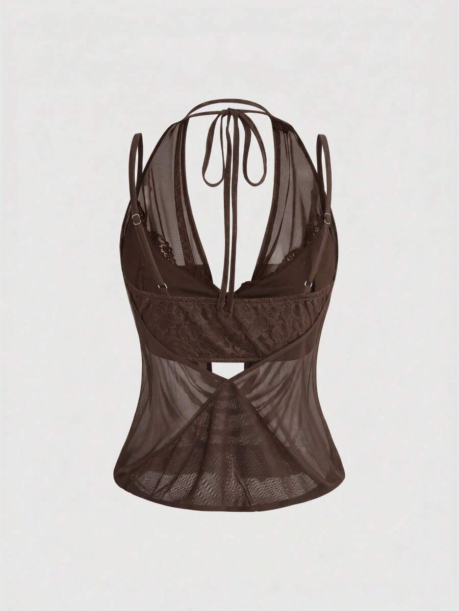 Women wearing a black draped backless halter crop top layered over a boned lace camisole.