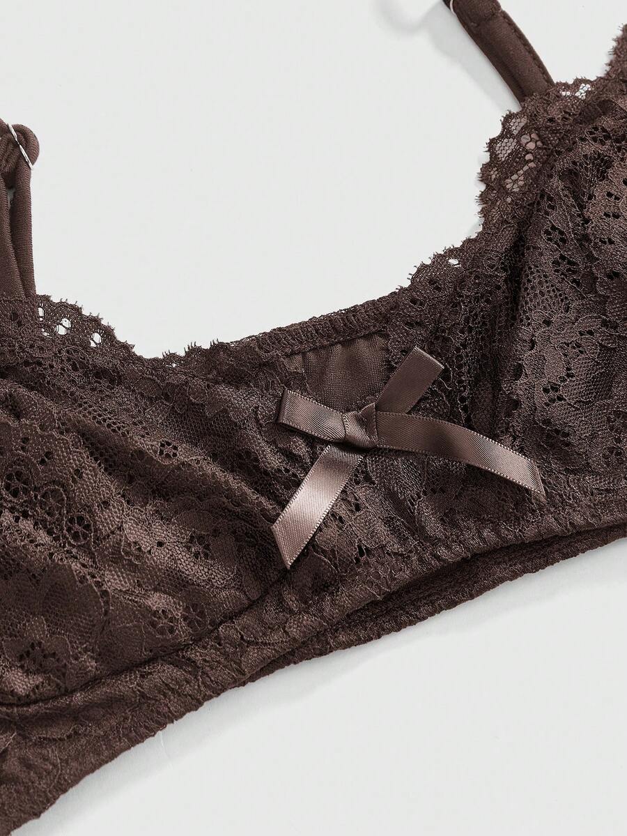 Women wearing a black draped backless halter crop top layered over a boned lace camisole.