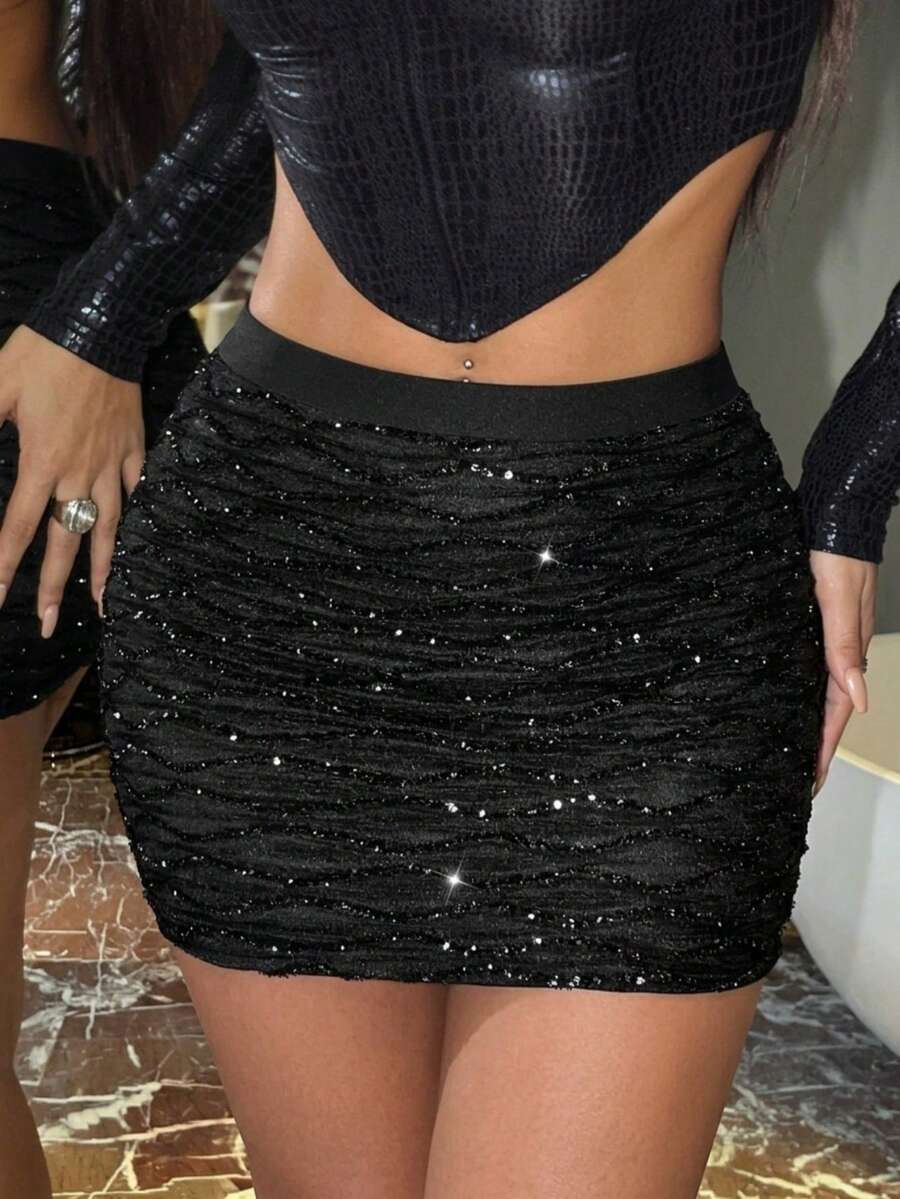 Black high waist bodycon mini skirt with contrast sequin detailing, ruched design, and metallic finish.