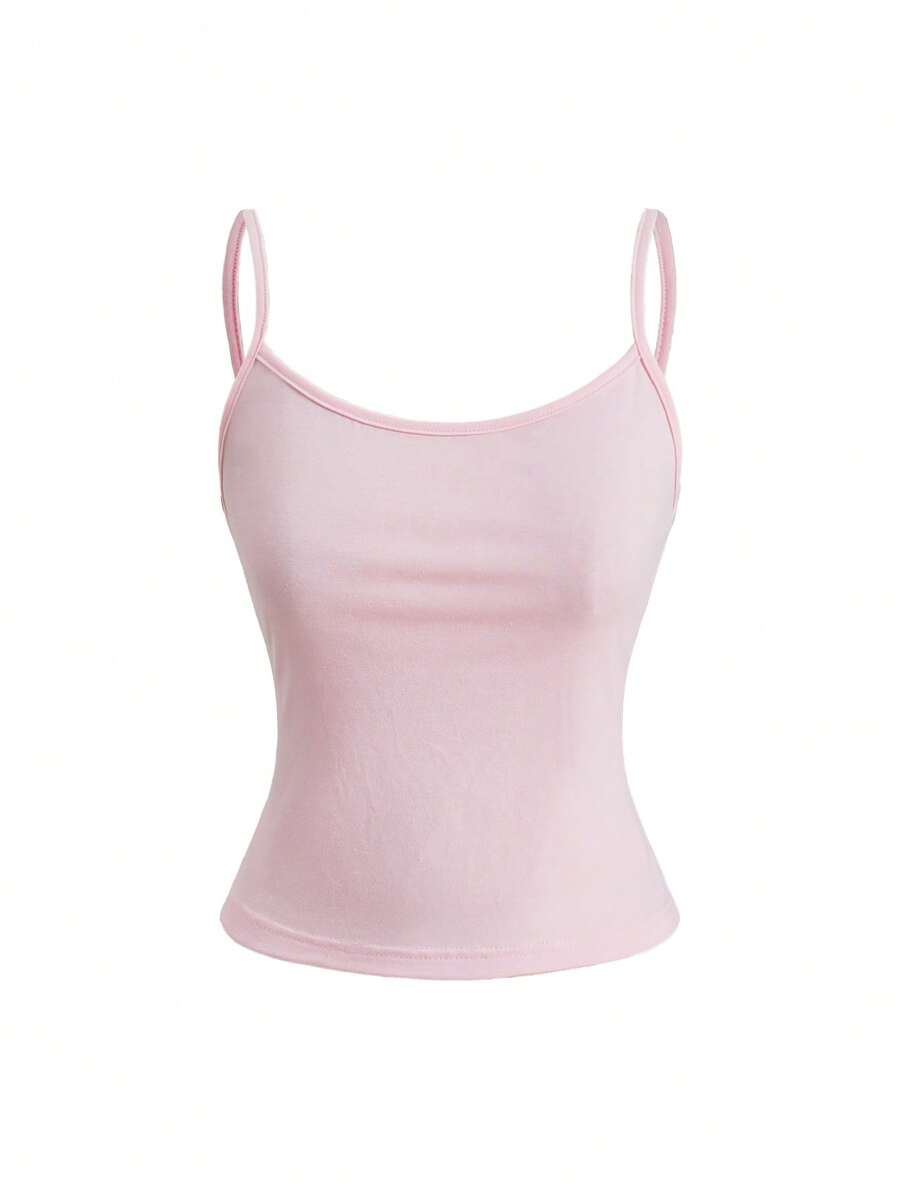 Woman wearing a black backless halter tank top with criss-cross details and textured knit fabric