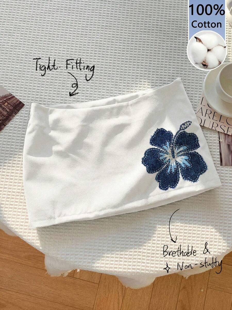 Women's white 100% cotton low waist mini skirt featuring a tropical print and zipper detail.