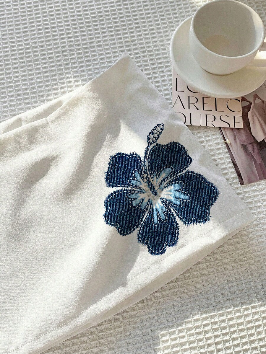 Women's white 100% cotton low waist mini skirt featuring a tropical print and zipper detail.
