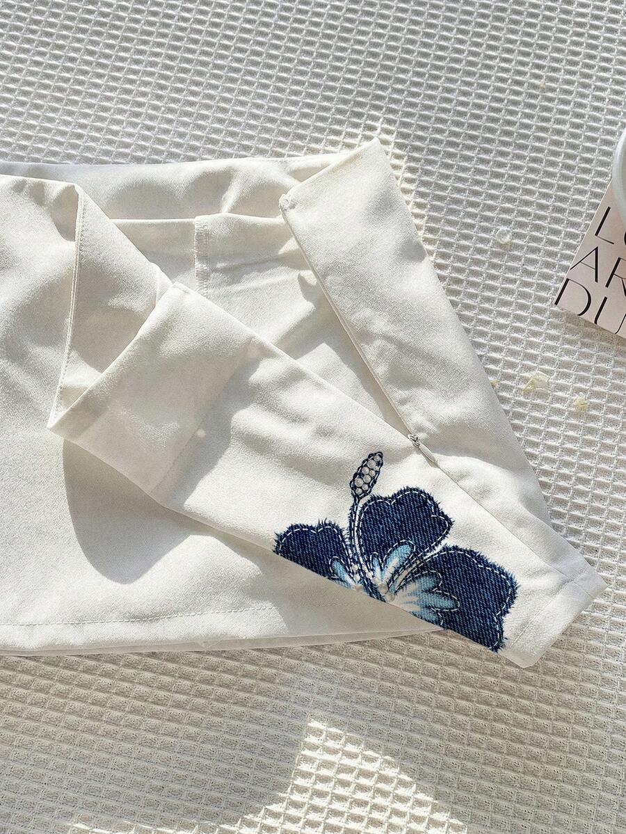 Women's white 100% cotton low waist mini skirt featuring a tropical print and zipper detail.
