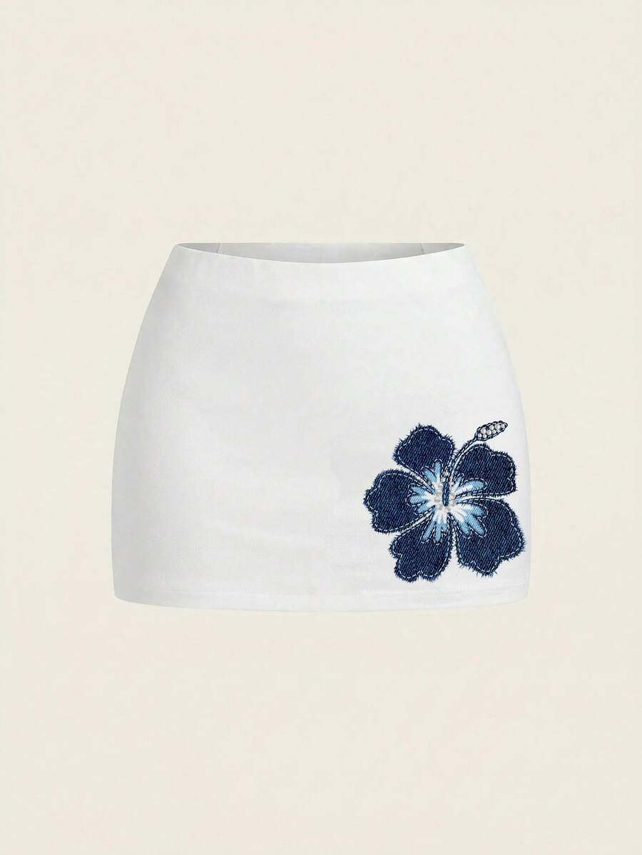 Women's white 100% cotton low waist mini skirt featuring a tropical print and zipper detail.