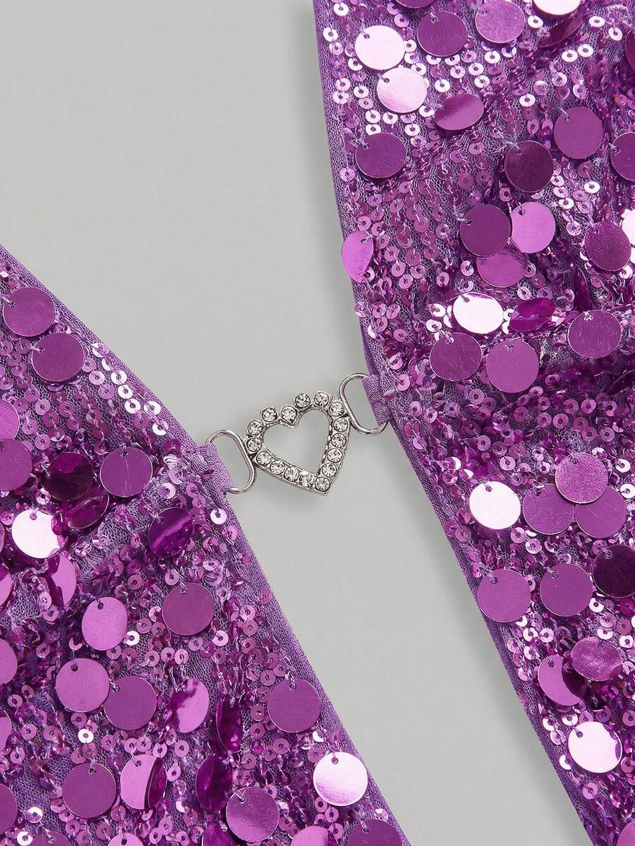 A woman wearing a burgundy sequin halter camisole top featuring a backless asymmetrical design.