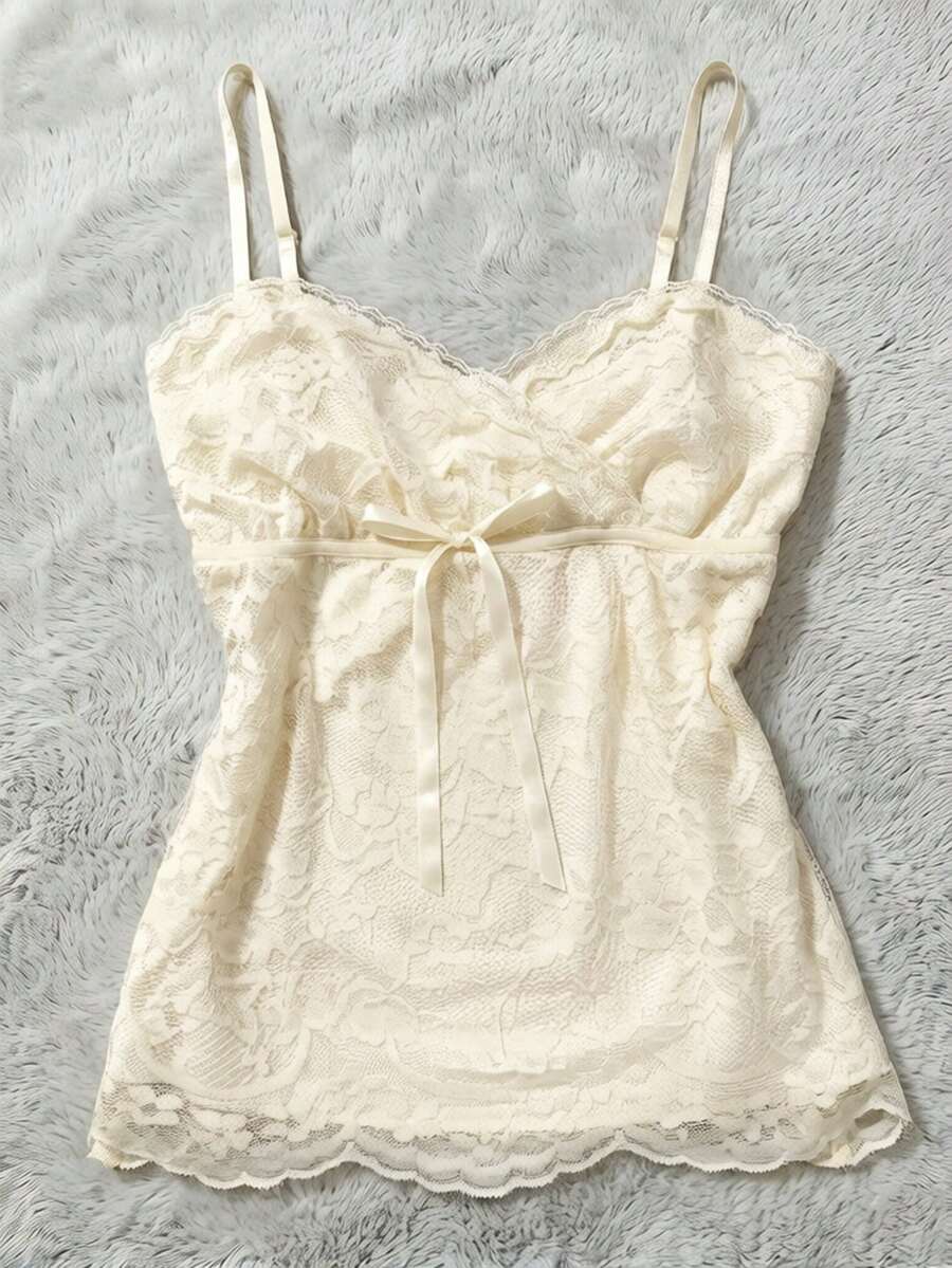 Women's solid color elegant lace cami top featuring contrast lace trim, cinched waist, spaghetti straps, and backless ring detail.