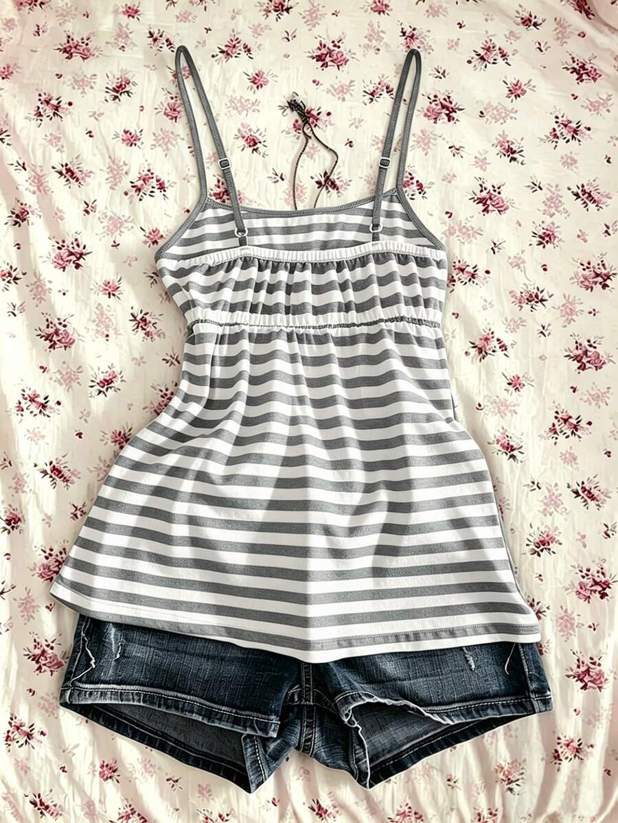 A women's black striped camisole top featuring spaghetti straps, a backless design with ring detail, and high-stretch knitted fabric.