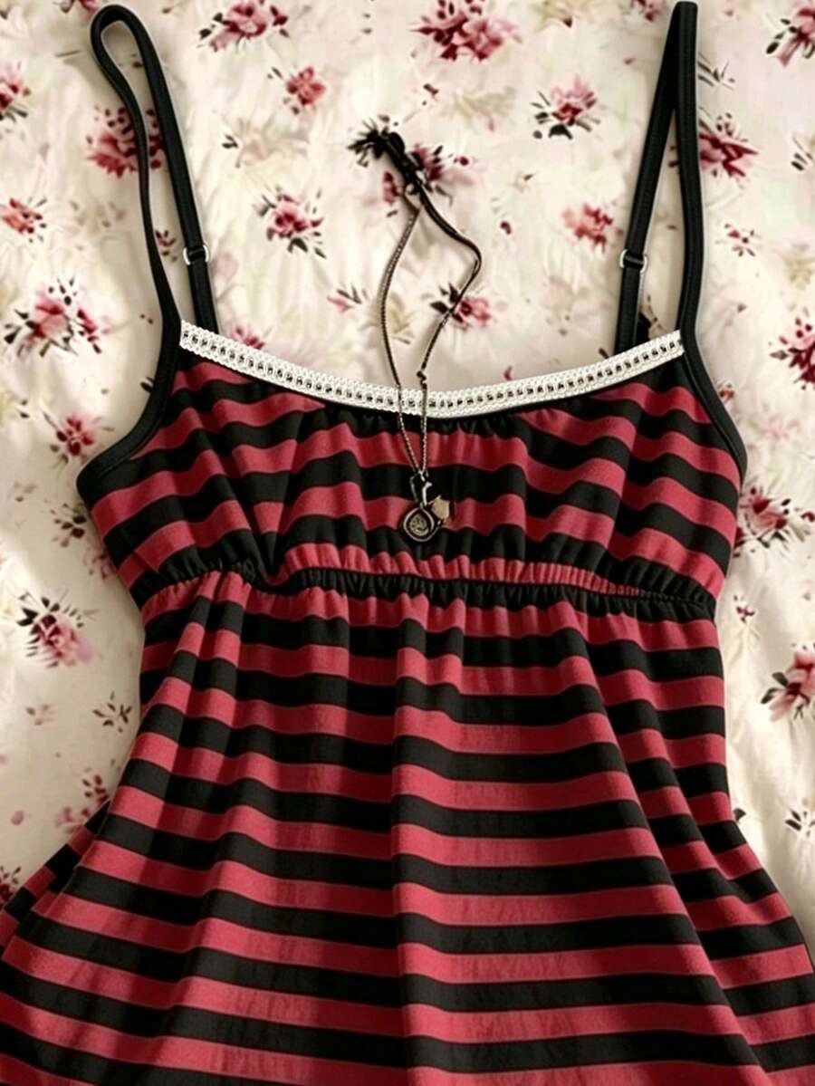 A women's black striped camisole top featuring spaghetti straps, a backless design with ring detail, and high-stretch knitted fabric.