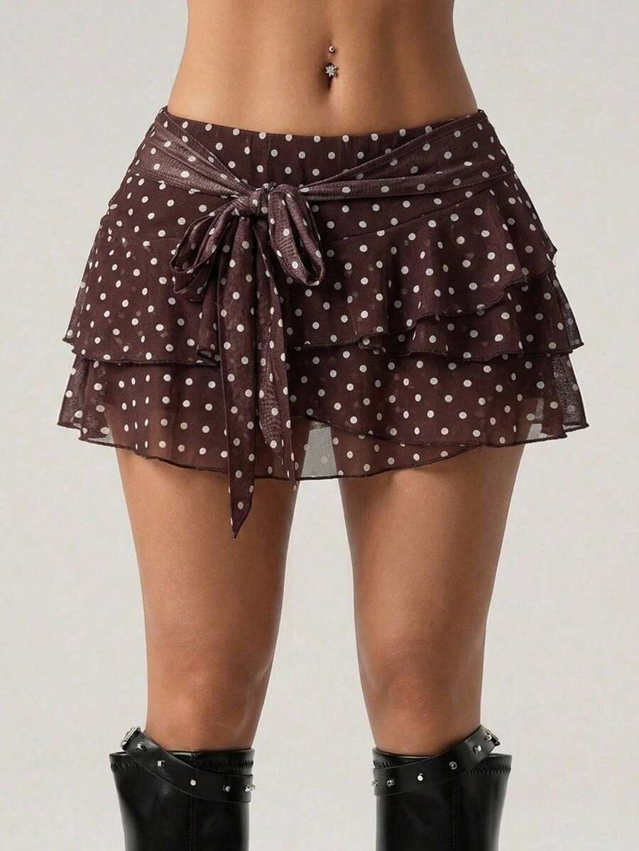 White tiered ruffle trim mini skirt for women with low waist, knot detail, mesh fabric, and casual Y2K boho design.