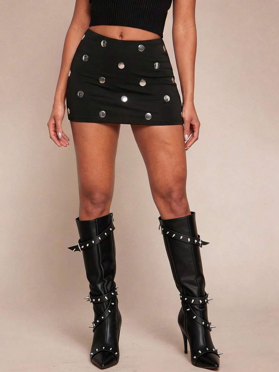 Women's black bodycon mini skort featuring a low waist, pleated side split hem, zipper closure, and built-in shorts.