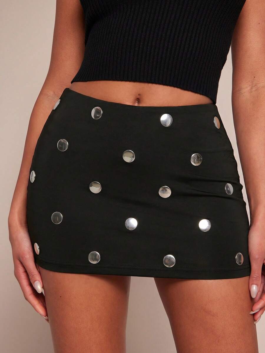 Women's black bodycon mini skort featuring a low waist, pleated side split hem, zipper closure, and built-in shorts.