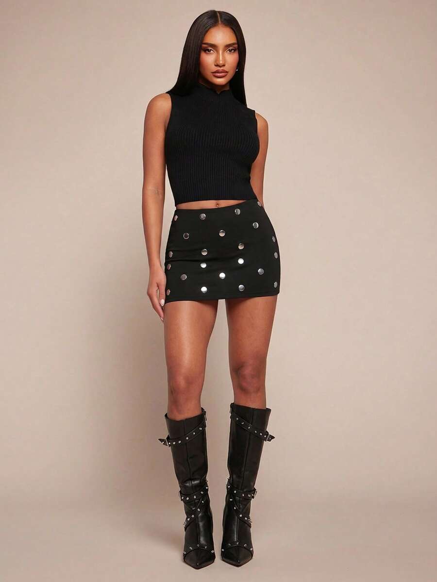 Women's black bodycon mini skort featuring a low waist, pleated side split hem, zipper closure, and built-in shorts.