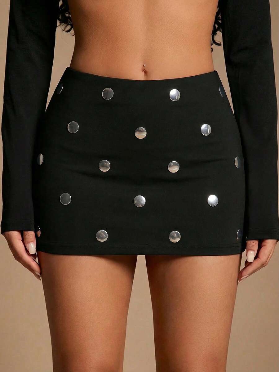 Women's black bodycon mini skort featuring a low waist, pleated side split hem, zipper closure, and built-in shorts.