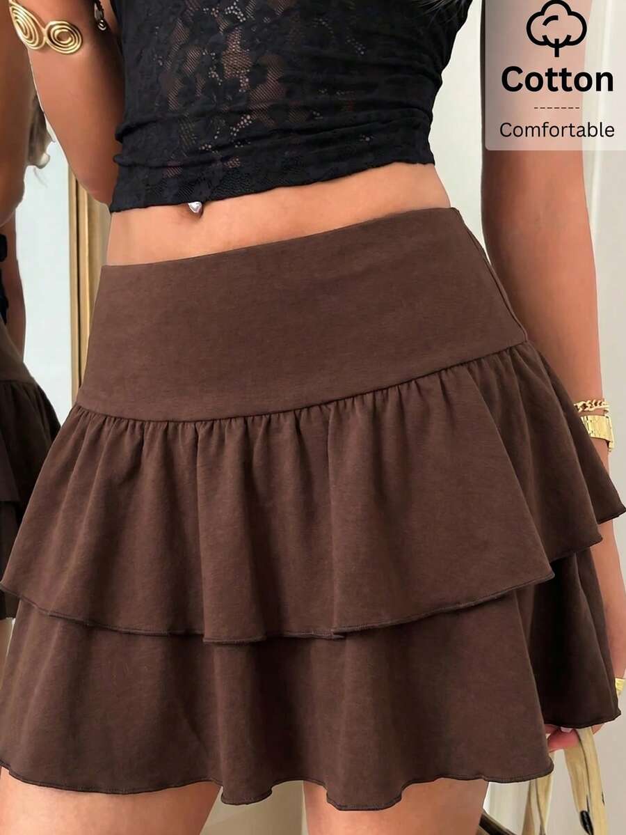 Black low waist knit mini skirt featuring a tiered ruffle hem and skinny high stretch fit.