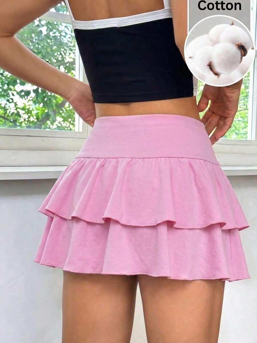 Black low waist knit mini skirt featuring a tiered ruffle hem and skinny high stretch fit.